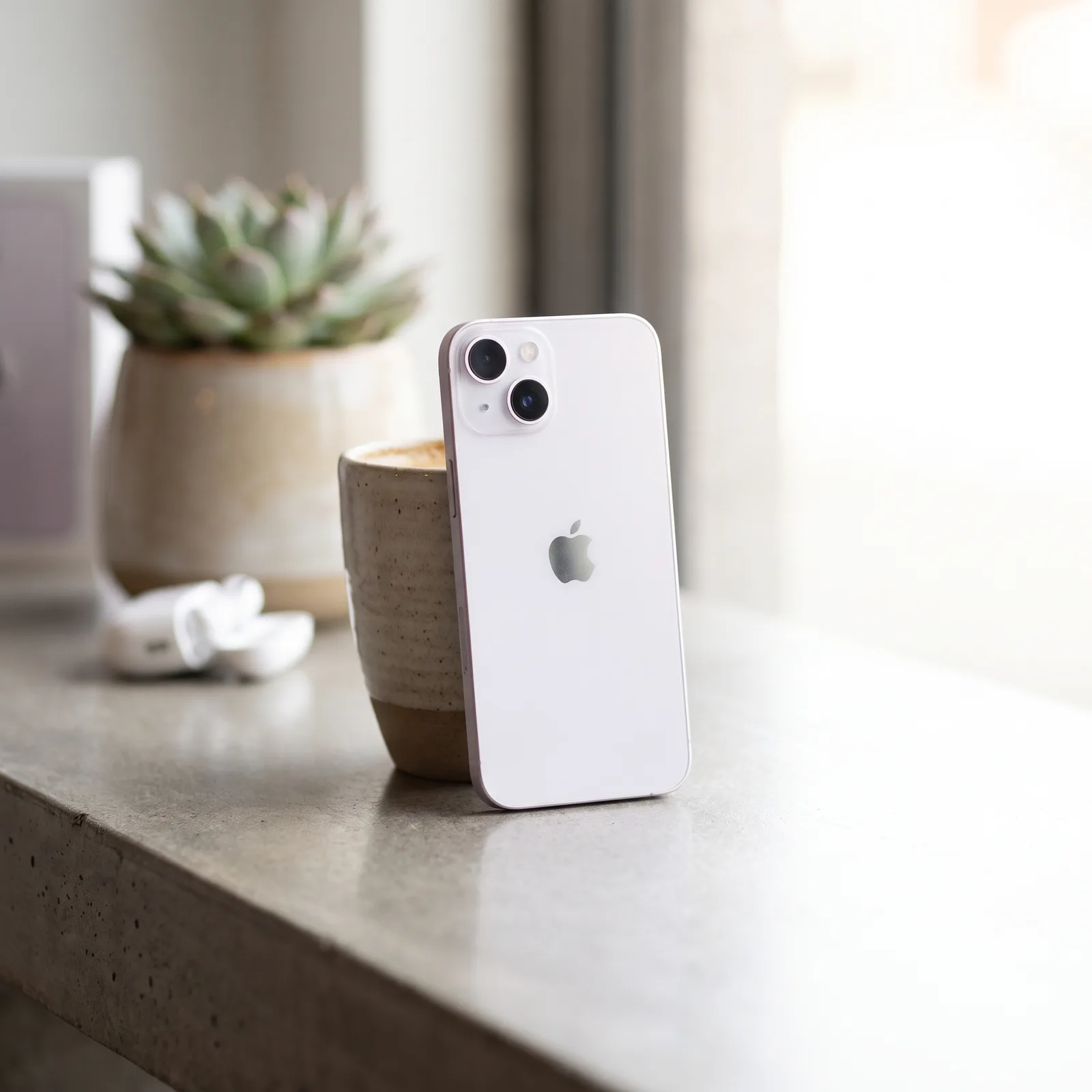 Lifestyle shot of person holding refurbished purple iPhone 14, showcasing its vibrant display and colour. MTM IT.